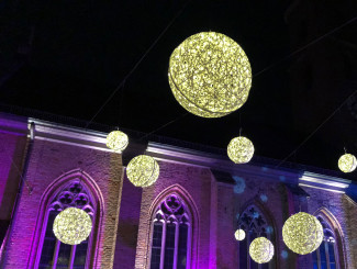 leuchtende Kugeln vor einer Kirche in der Nacht